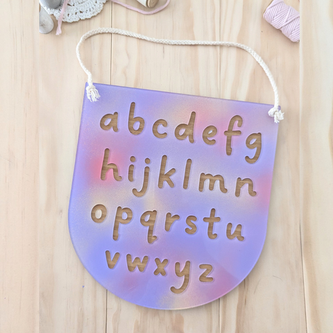 Handmade pastel alphabet plaque made from acrylic and bamboo, perfect for playroom or classroom wall decor with a white hanging cord.