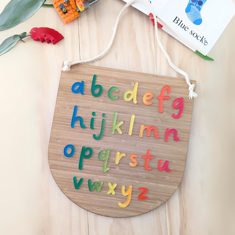 Handcrafted Rainbow Alphabet Learning Plaque made from acrylic and bamboo for kids' playroom or classroom decor.